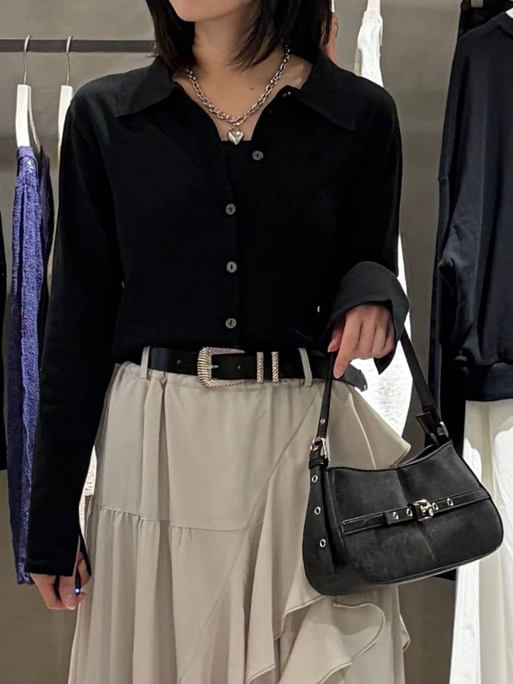 ベージュ系のスカート、ブラック系のハンドバッグ、ブラック系のカーディガン/ボレロを着用したレディースの春コーディネートの4枚目の写真