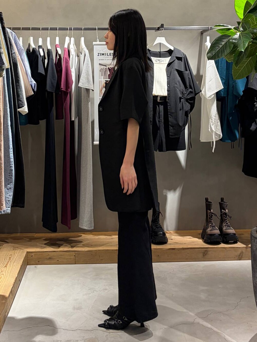 ブラック系のキャミソール、ブラック系のデニムパンツ、ブラック系のサンダルを着用したレディースの春コーディネートの2枚目の写真