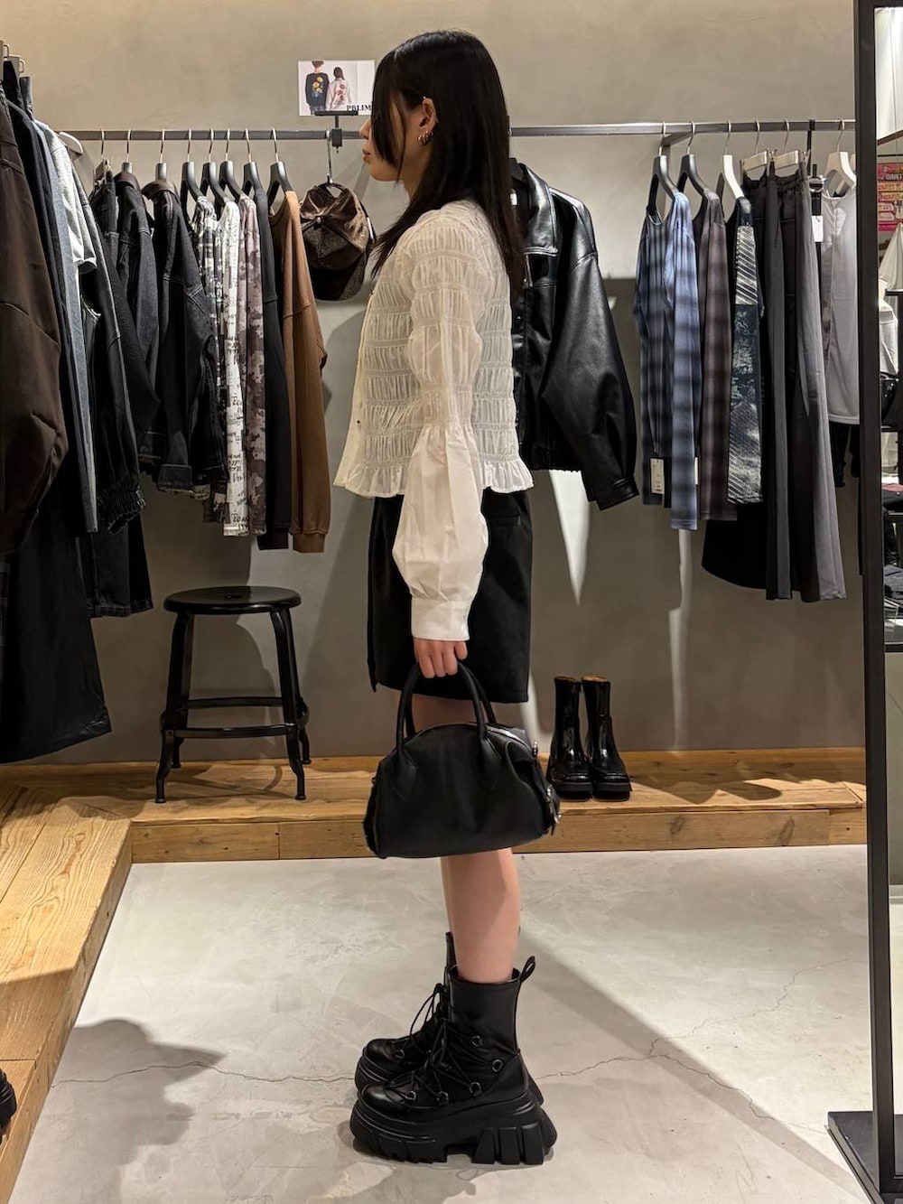 ブラック系のブーツ、ブラック系のその他パンツ、ホワイト系のTシャツ/カットソーを着用したレディースの秋コーディネートの2枚目の写真