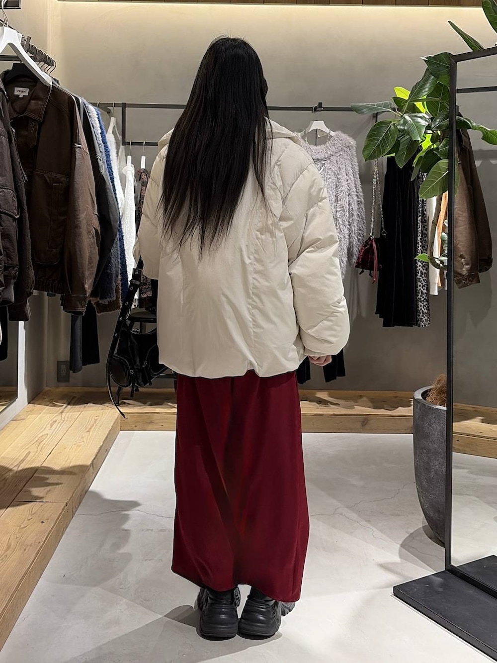 ブラック系のブーツ、ホワイト系のブルゾン、ブラック系のニット/セーターを着用したレディースの冬コーディネートの3枚目の写真