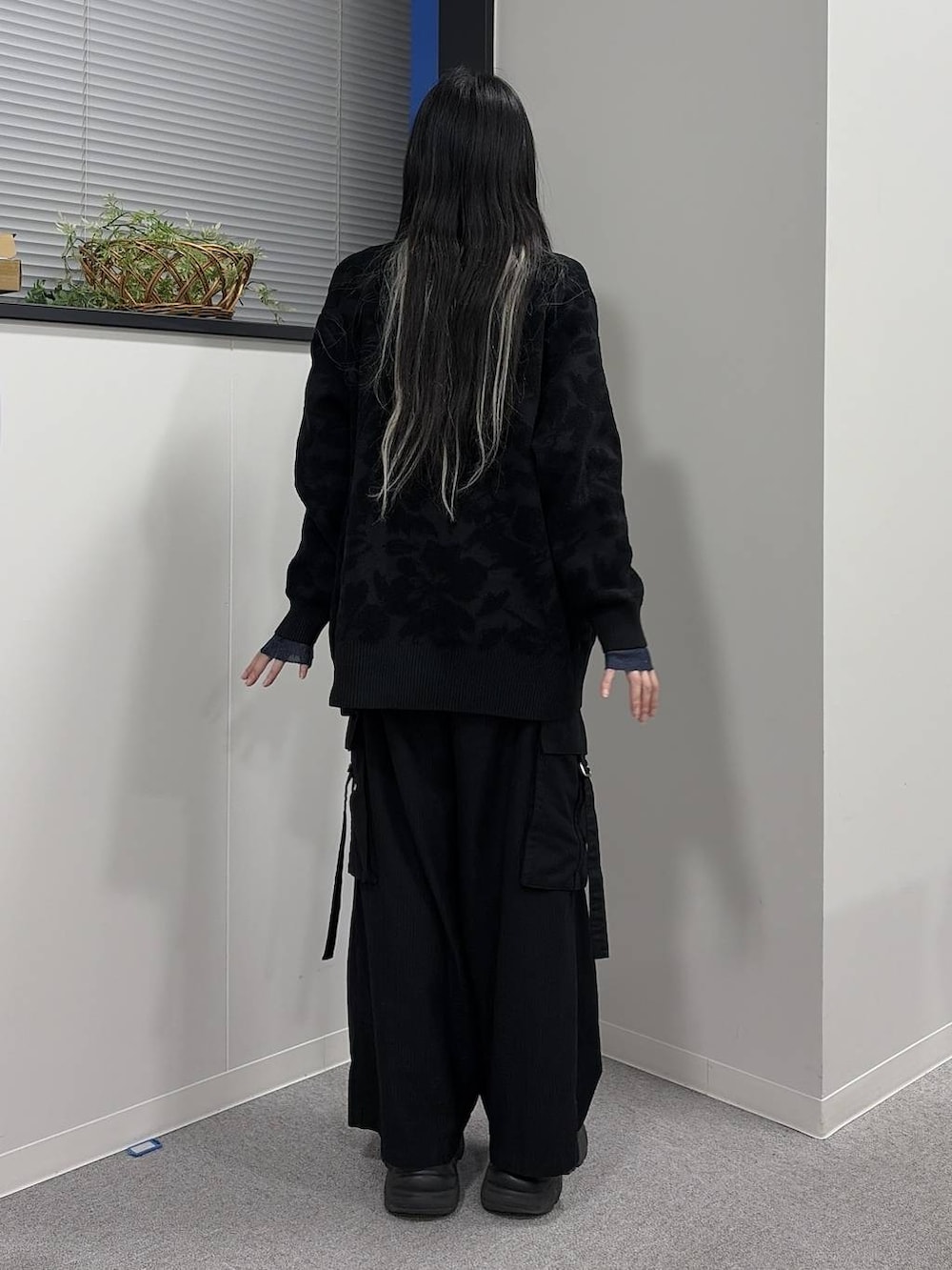 ブラック系のブーツ、ブラック系のスラックス、グリーン系のニット/セーターを着用したレディースの冬コーディネートの3枚目の写真