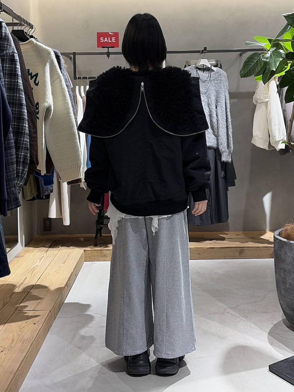 ブラック系のブーツ、ブラック系のブルゾン、ブラック系のボストンバッグを着用したレディースの冬コーディネートの3枚目の写真