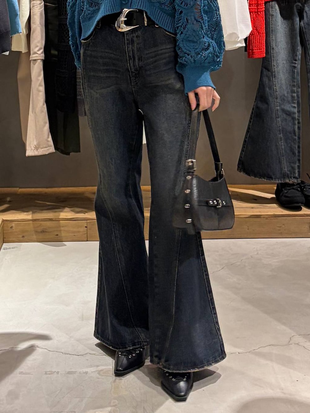 ブルー系のカーディガン/ボレロ、ブルー系のデニムパンツ、ブラック系のハンドバッグを着用したレディースの春コーディネートの5枚目の写真