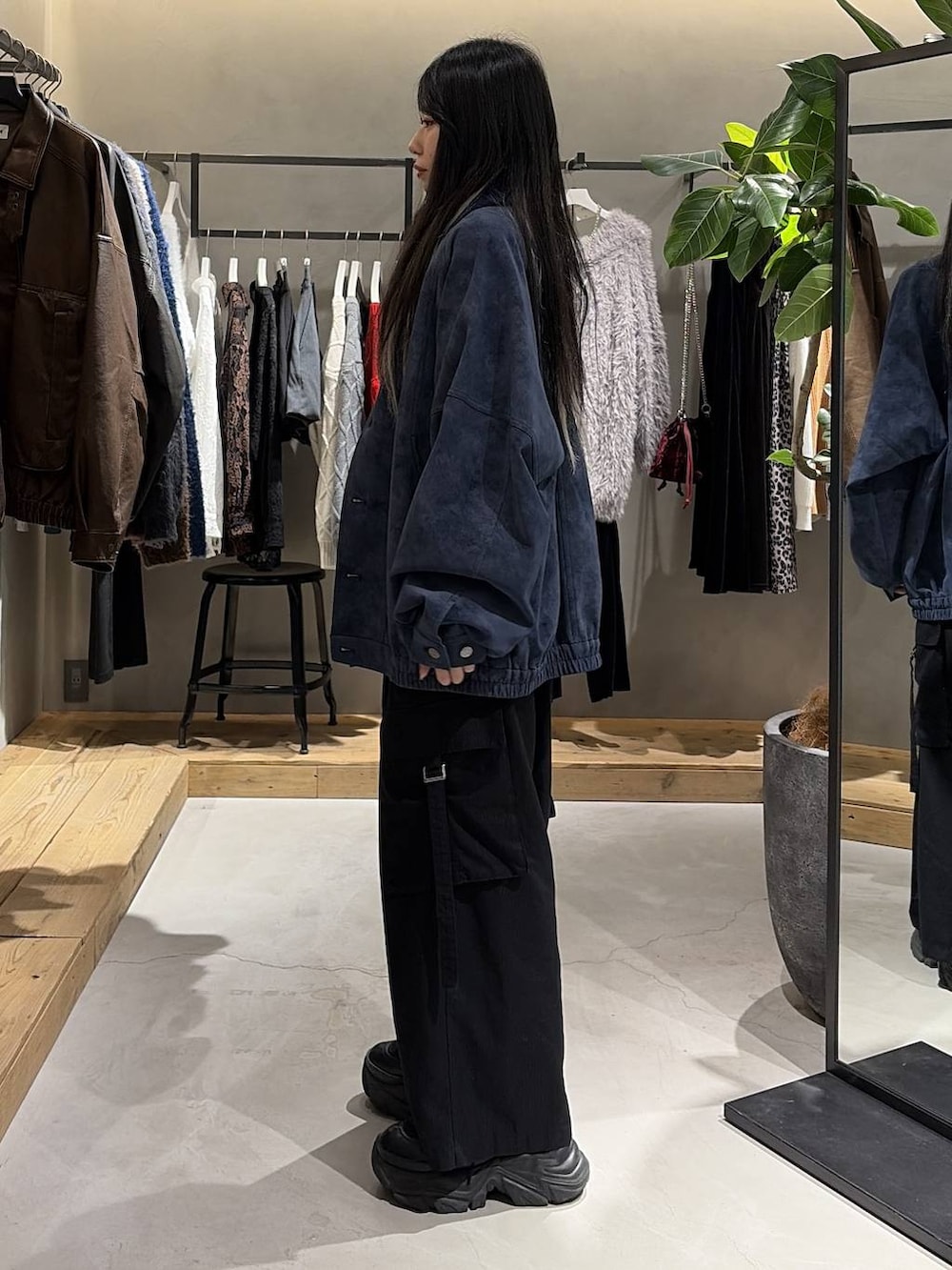 ブラック系のブーツ、ブラック系のスラックス、ブルー系のブルゾンを着用したレディースの冬コーディネートの2枚目の写真