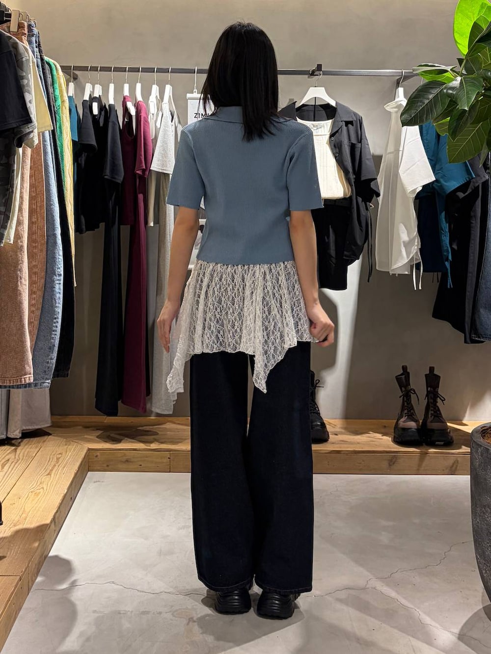 ブルー系のデニムパンツ、ブラック系のサンダル、ホワイト系のチュニックを着用したレディースの春コーディネートの3枚目の写真