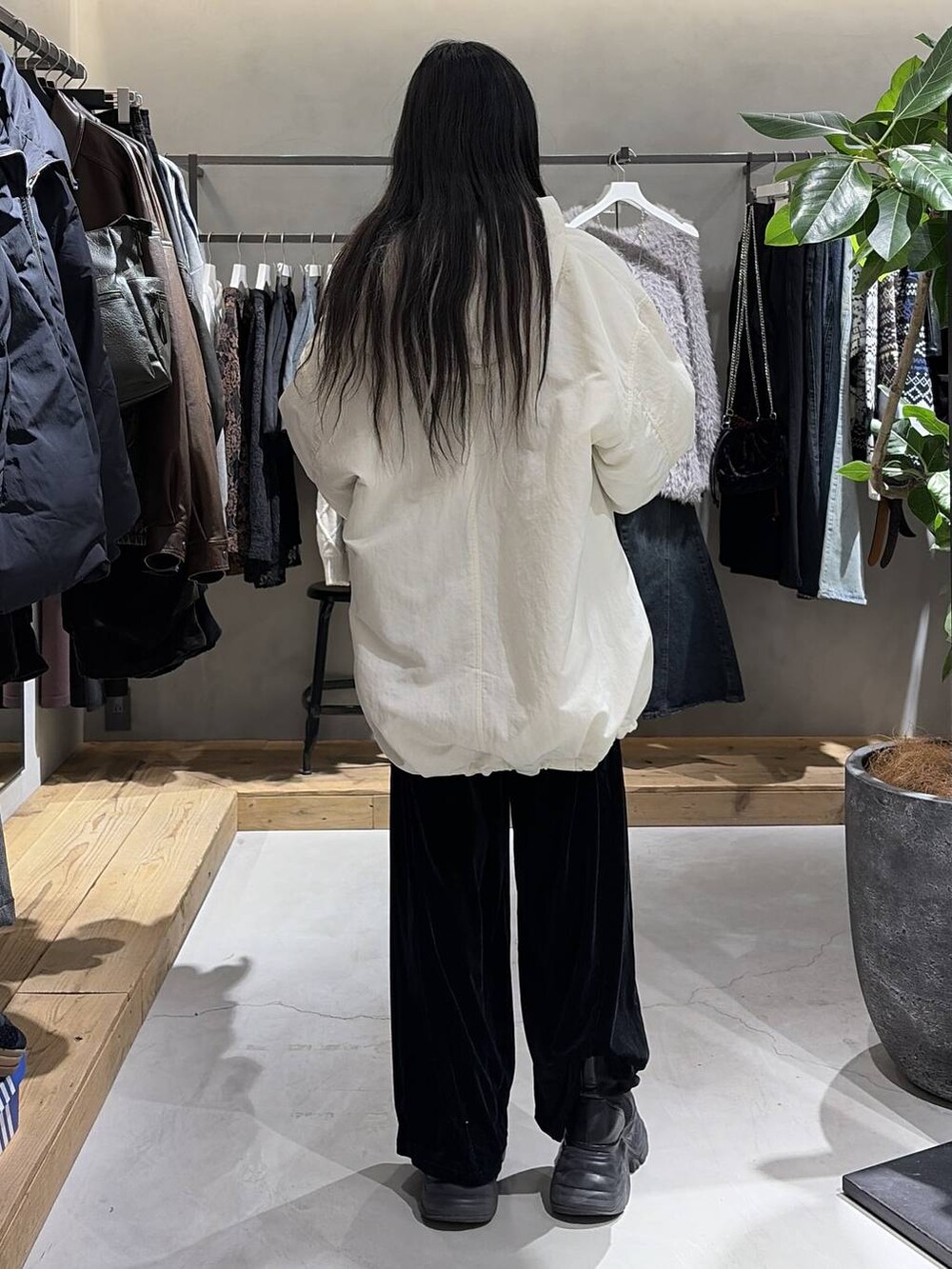 ブラック系のブーツ、ホワイト系のカーディガン/ボレロ、ホワイト系のブルゾンを着用したレディースの冬コーディネートの3枚目の写真