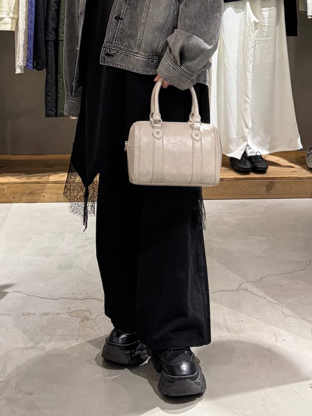 ブラック系のブーツ、ブラック系のデニムパンツ、ホワイト系のボストンバッグを着用したレディースの冬コーディネートの5枚目の写真