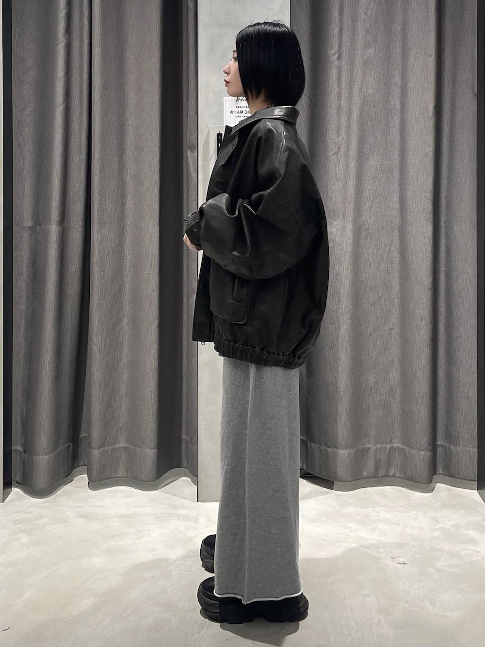 ブラック系のブーツ、グレー系のスウェットパンツ、ブラック系のブルゾンを着用したレディースの秋コーディネートの2枚目の写真