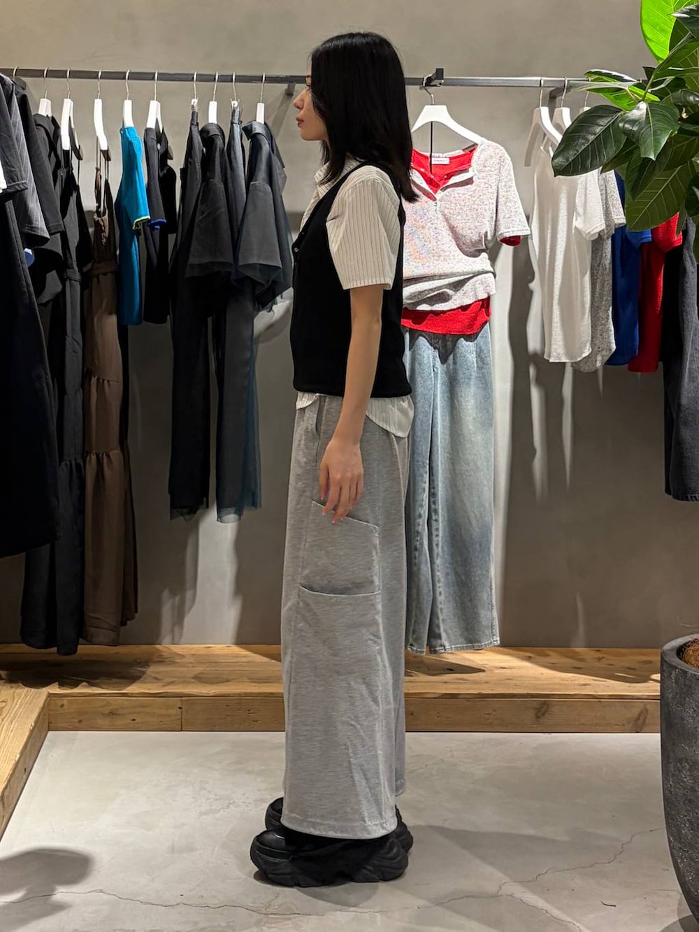 ブラック系のタンクトップ、グレー系のスウェットパンツ、ホワイト系のシャツ/ブラウスを着用したレディースの春コーディネートの2枚目の写真