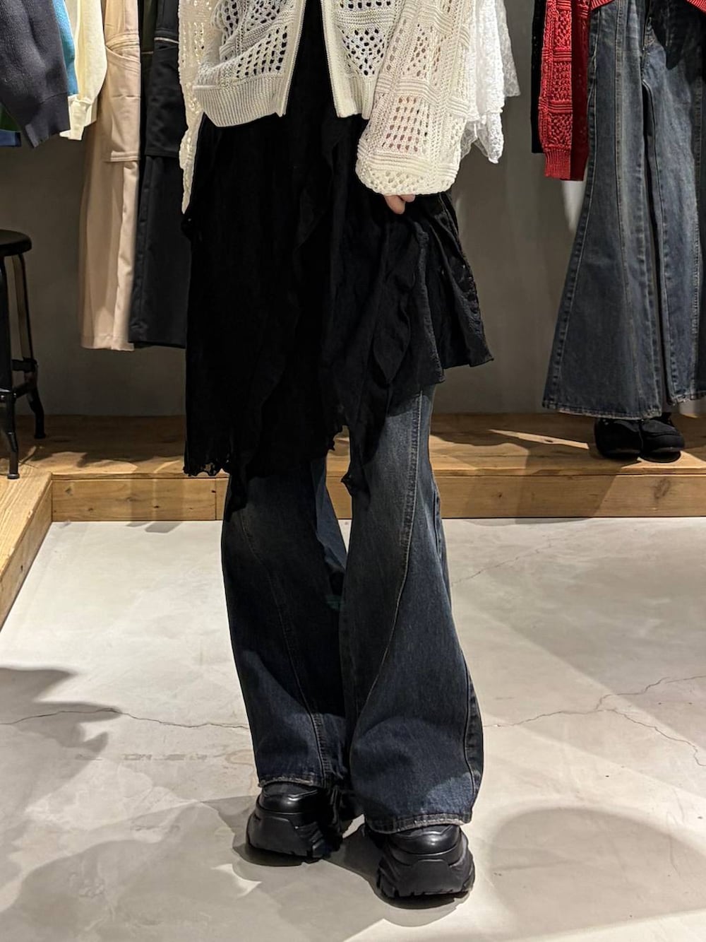 ブラック系のブーツ、ブルー系のデニムパンツ、ホワイト系のパーカーを着用したレディースの春コーディネートの5枚目の写真