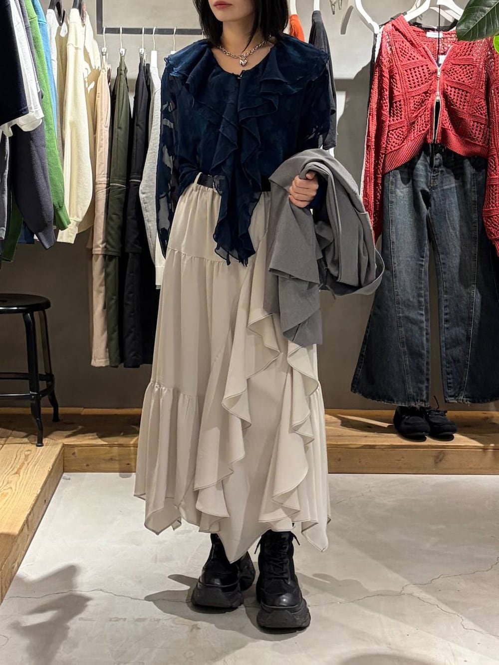 ブラック系のブーツ、ベージュ系のスカート、グレー系のテーラードジャケットを着用したレディースの春コーディネートの6枚目の写真