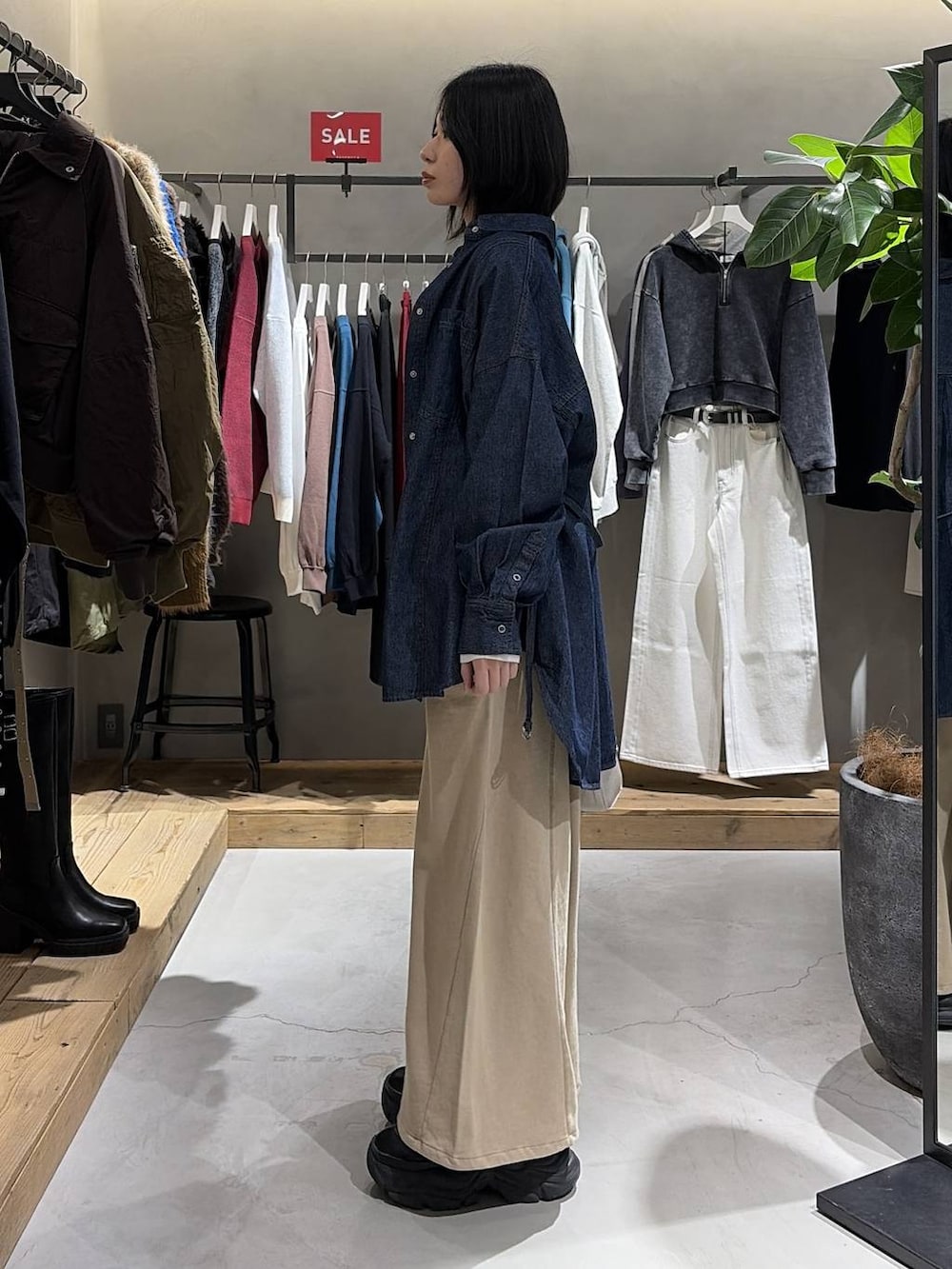 ブラック系のブーツ、ホワイト系のボストンバッグ、ブラウン系のスウェットパンツを着用したレディースの冬コーディネートの2枚目の写真