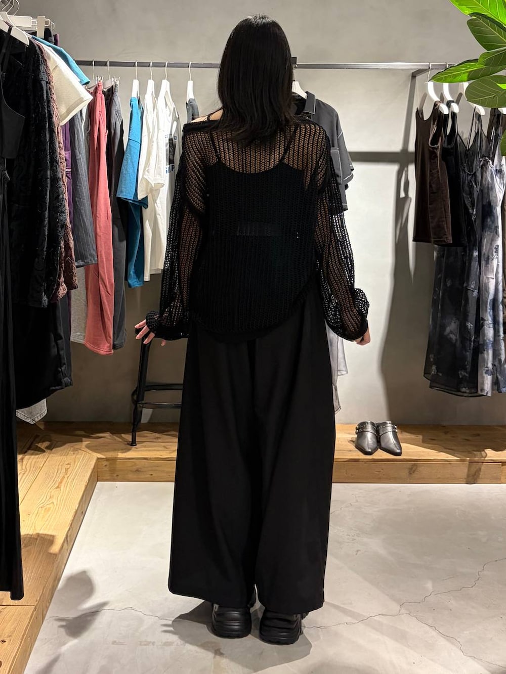 ブラック系のスラックス、ブラック系のスニーカー、ブラック系のニット/セーターを着用したレディースの夏コーディネートの3枚目の写真