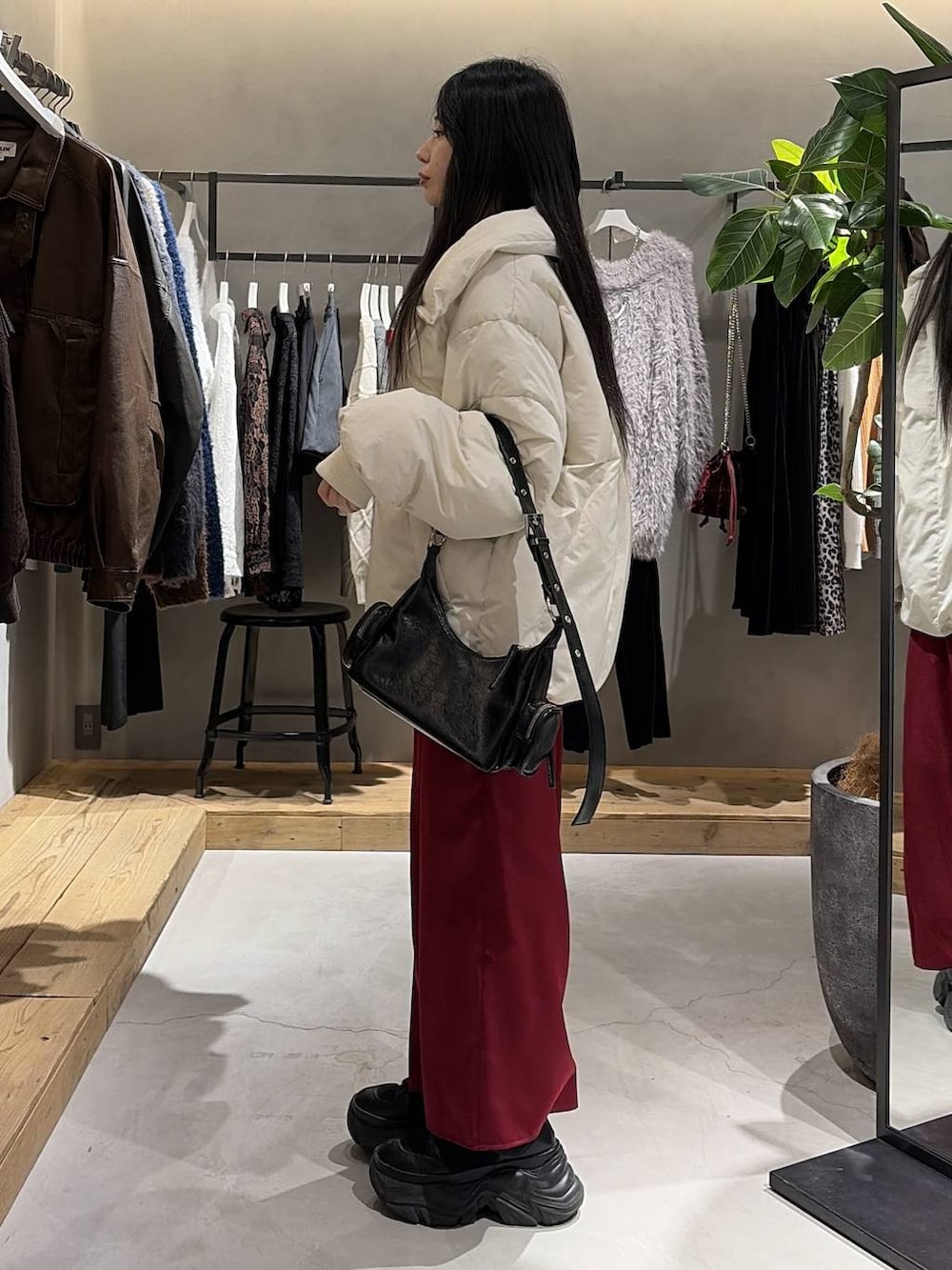 ブラック系のブーツ、ホワイト系のブルゾン、ブラック系のニット/セーターを着用したレディースの冬コーディネートの2枚目の写真