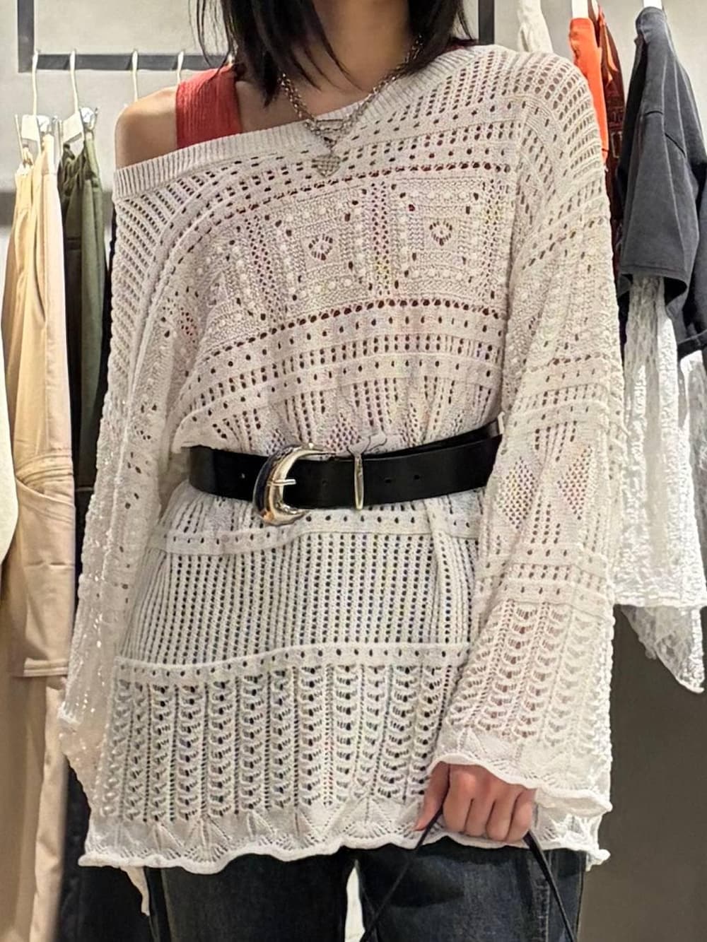 ブラック系のブーツ、ブルー系のデニムパンツ、ブラック系のハンドバッグを着用したレディースの春コーディネートの4枚目の写真