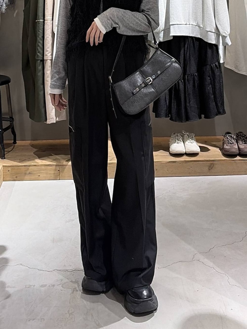 ブラック系のブーツ、ブラック系のハンドバッグ、ブラック系のスラックスを着用したレディースの冬コーディネートの5枚目の写真