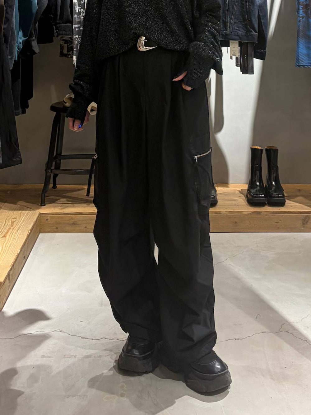 ブラック系のカーゴパンツ、ブラック系のニット/セーター、ブラック系のブーツを着用したレディースの秋コーディネートの5枚目の写真