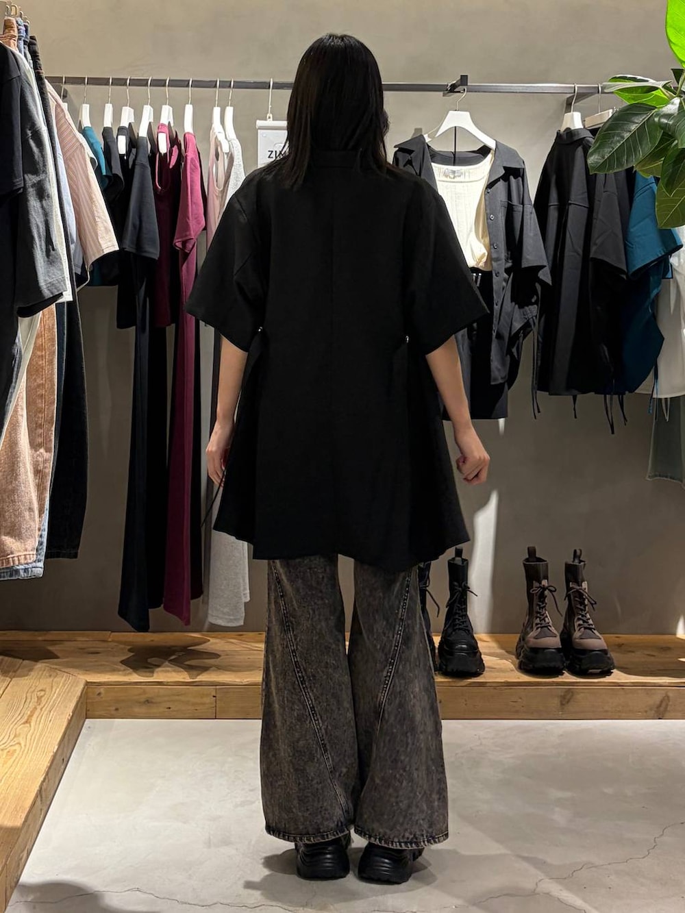 ブラック系のデニムパンツ、ブラック系のサンダル、ブラック系のテーラードジャケットを着用したレディースの春コーディネートの3枚目の写真