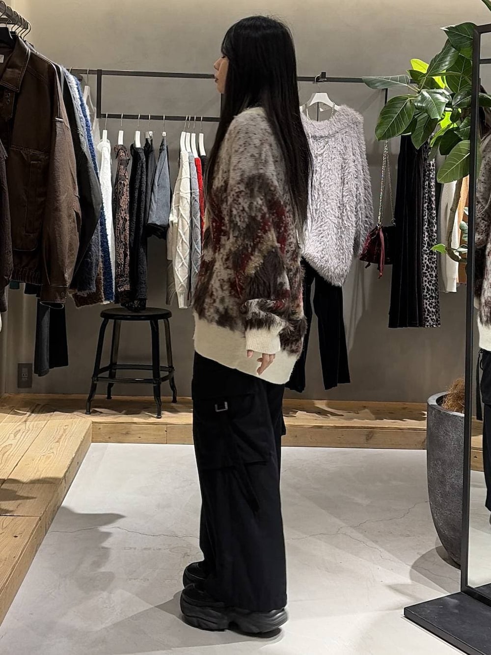 ブラック系のブーツ、ブラック系のスラックス、ホワイト系のカーディガン/ボレロを着用したレディースの冬コーディネートの2枚目の写真