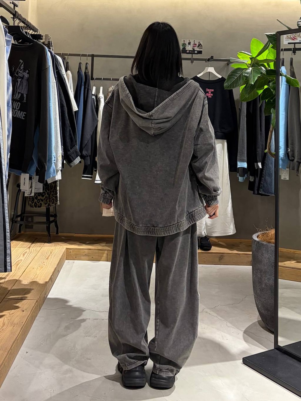 ブラック系のブーツ、ブラック系のデニムパンツ、ブラック系のパーカーを着用したレディースの春コーディネートの3枚目の写真