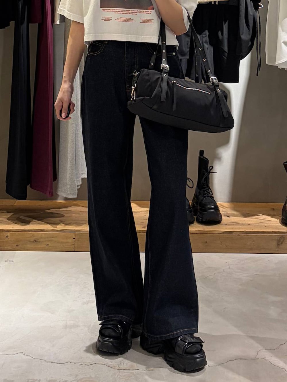 ブルー系のデニムパンツ、ブラック系のサンダル、ブラック系のトートバッグを着用したレディースの春コーディネートの5枚目の写真