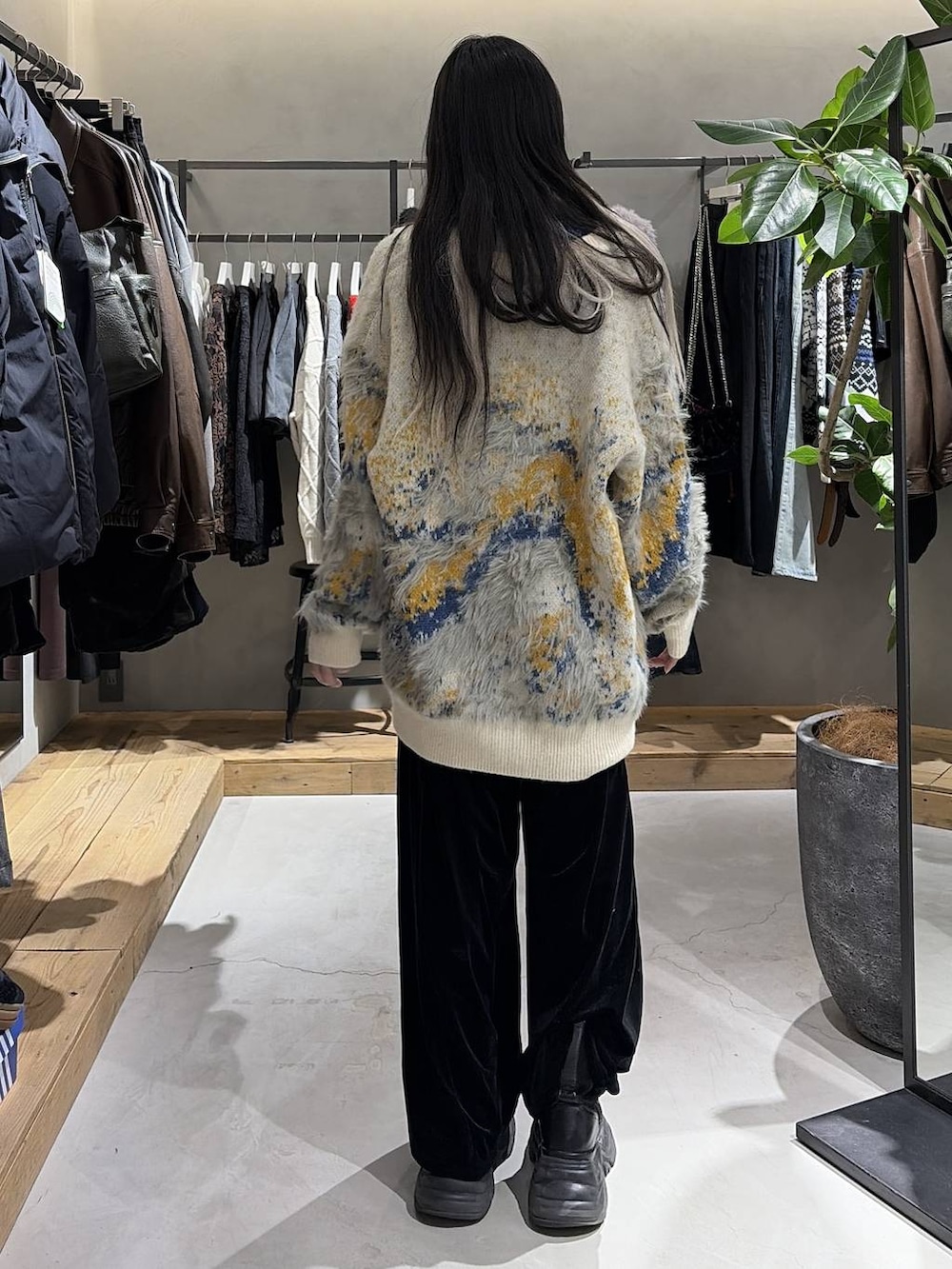 ブラック系のブーツ、ホワイト系のカーディガン/ボレロ、ブラック系のその他パンツを着用したレディースの冬コーディネートの3枚目の写真