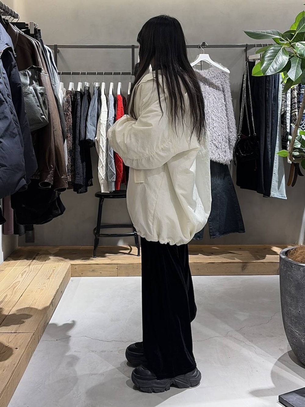 ブラック系のブーツ、ホワイト系のカーディガン/ボレロ、ホワイト系のブルゾンを着用したレディースの冬コーディネートの2枚目の写真