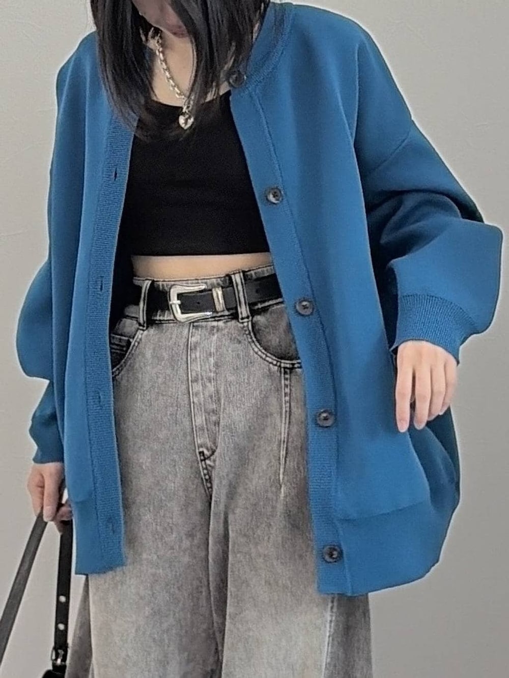 ブラック系のブーツ、ブラック系のハンドバッグ、ブルー系のカーディガン/ボレロを着用したレディースの冬コーディネートの4枚目の写真