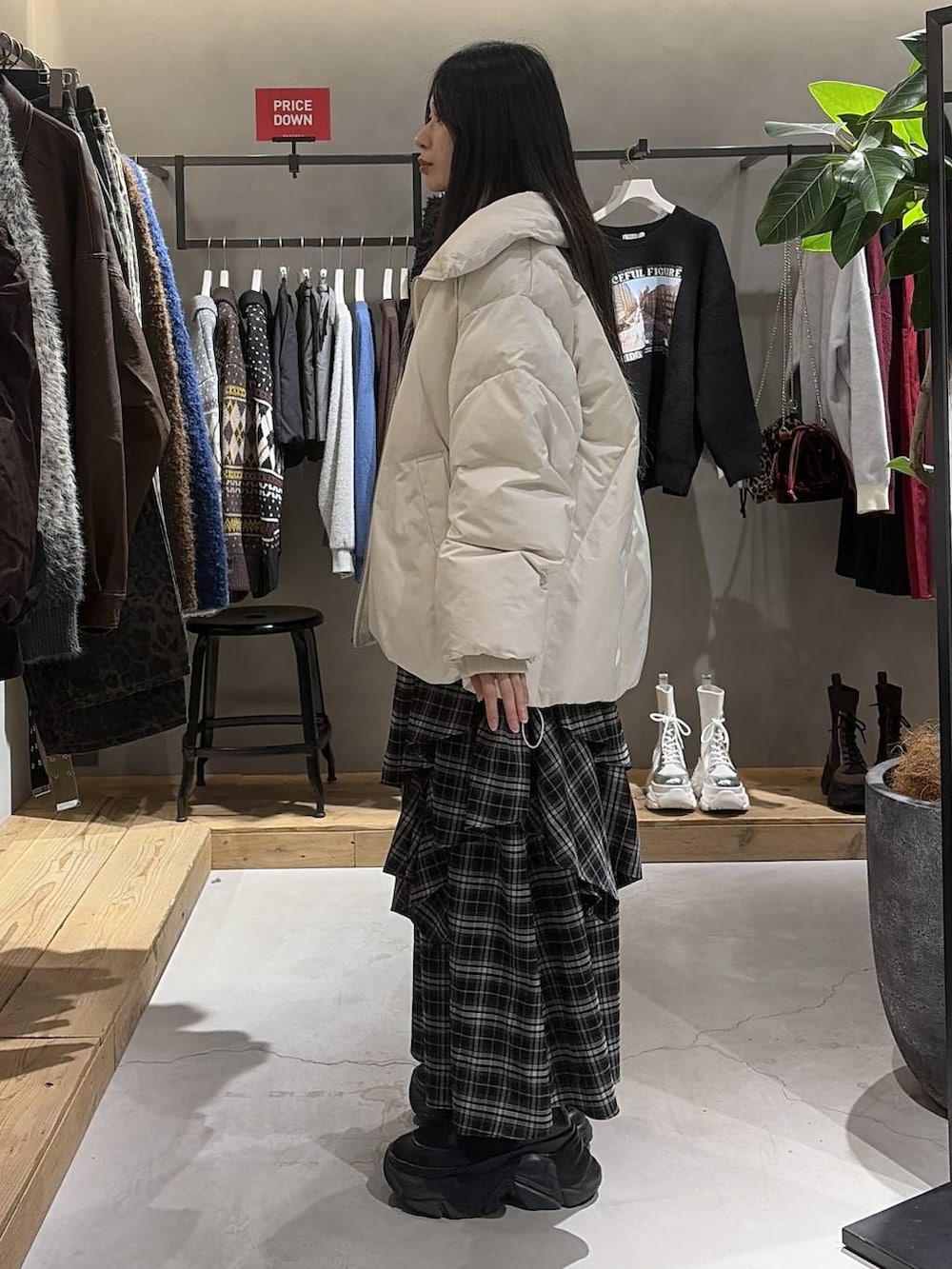 ブラック系のブーツ、ホワイト系のブルゾン、ホワイト系のスカートを着用したレディースの冬コーディネートの2枚目の写真