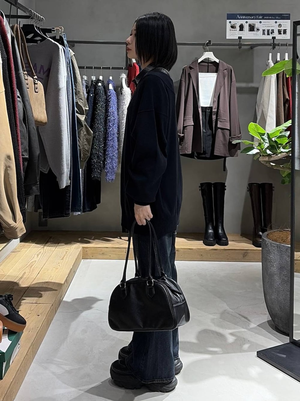 ブラック系のブーツ、ブルー系のデニムパンツ、ブラック系のシャツ/ブラウスを着用したレディースの秋コーディネートの2枚目の写真