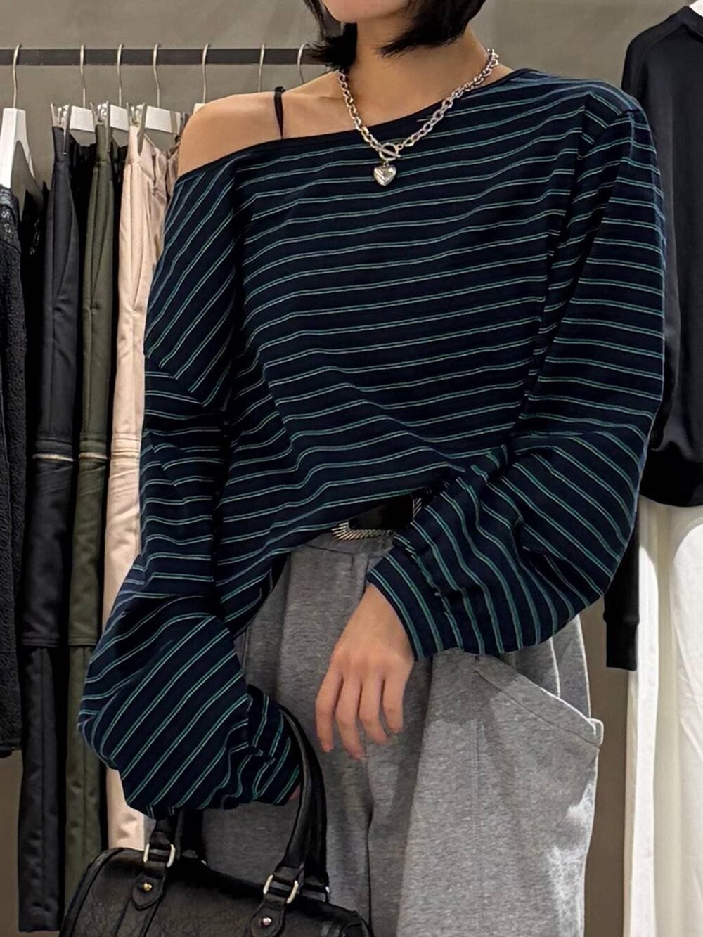 ブラック系のブーツ、ブラック系のボストンバッグ、グレー系のスウェットパンツを着用したレディースの冬コーディネートの4枚目の写真