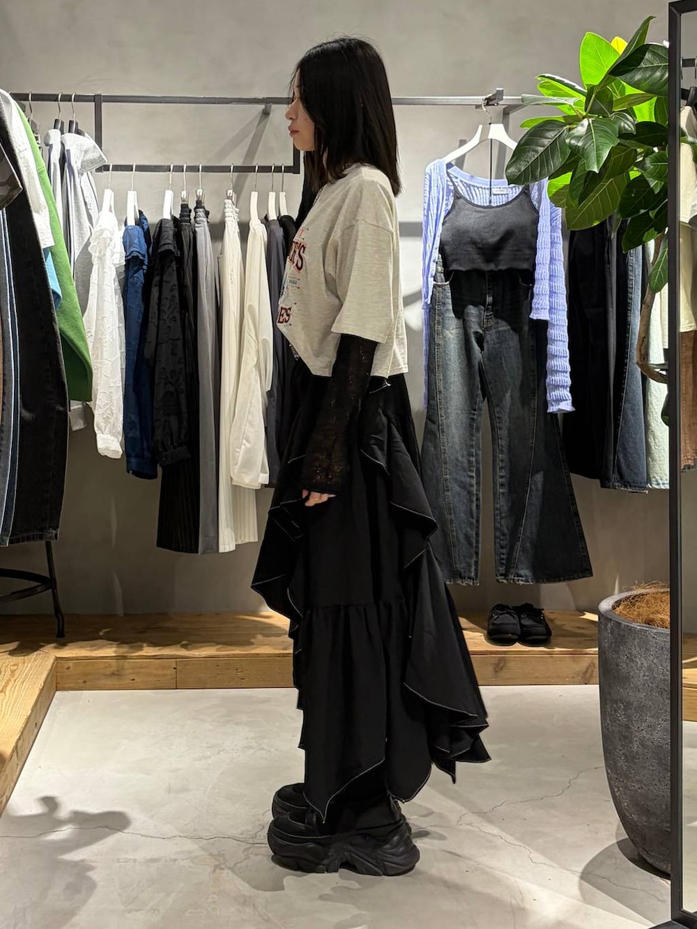 ブラック系のブーツ、ブラック系のスカート、ブラック系のTシャツ/カットソーを着用したレディースの春コーディネートの2枚目の写真