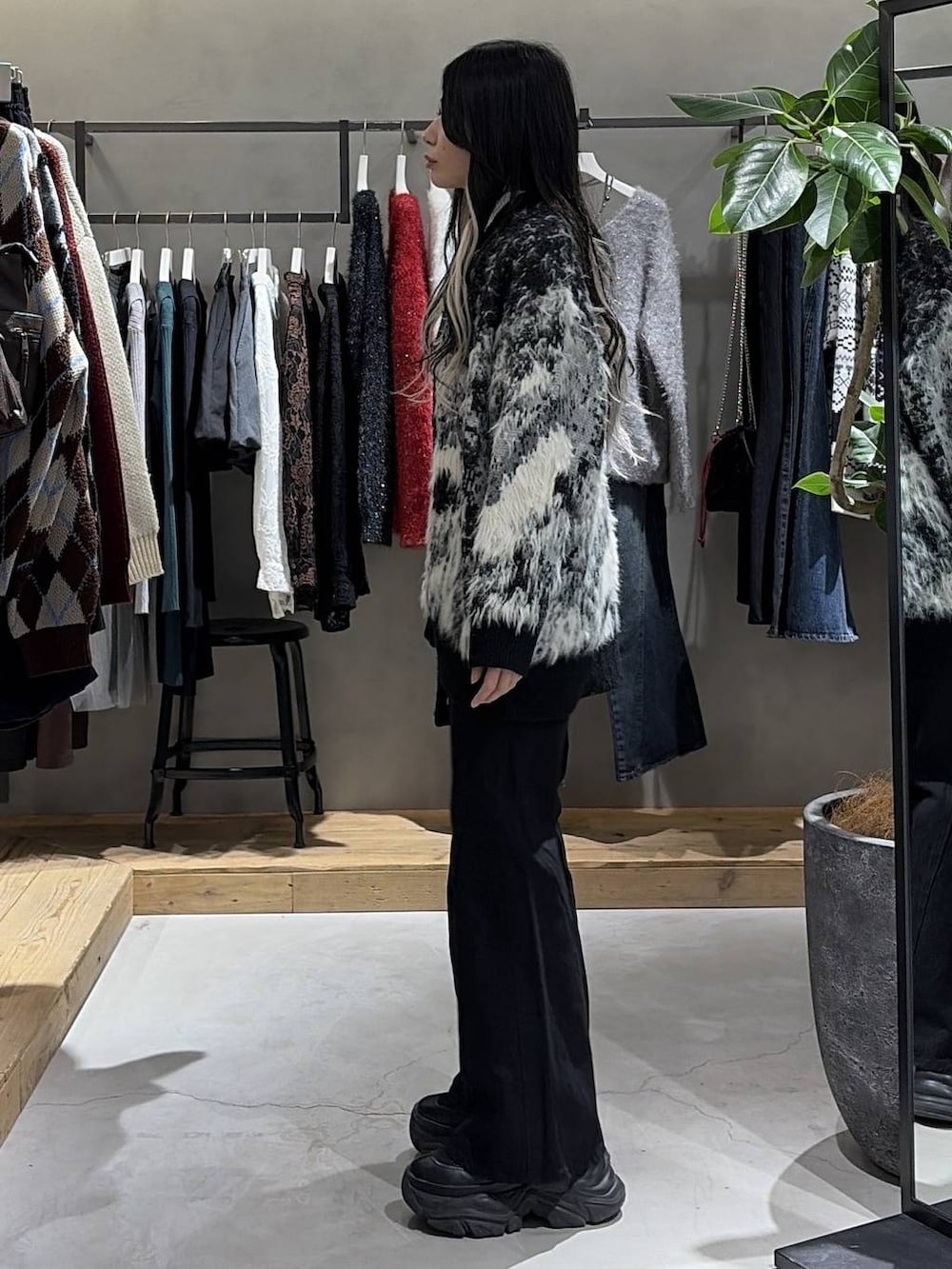 ブラック系のブーツ、ブラック系のデニムパンツ、ブラック系のカーディガン/ボレロを着用したレディースの冬コーディネートの2枚目の写真