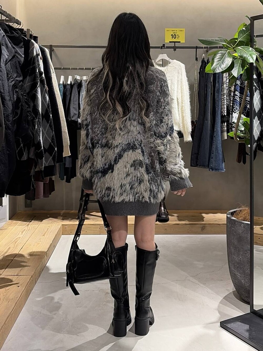 ブルー系のTシャツ/カットソー、グレー系のカーディガン/ボレロ、ブラック系のブーツを着用したレディースの秋コーディネートの3枚目の写真