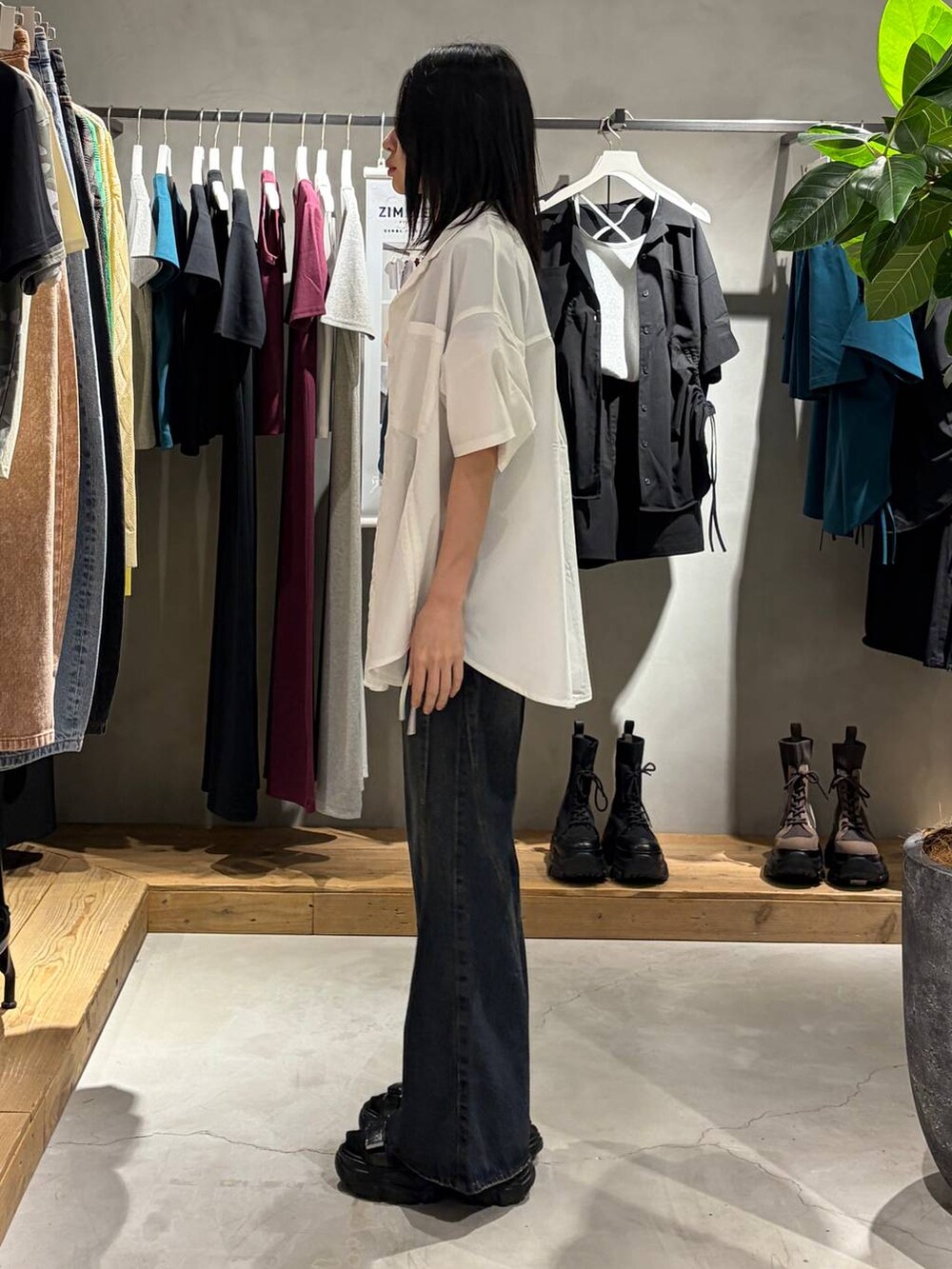 ブルー系のデニムパンツ、ブラック系のサンダル、ホワイト系のシャツ/ブラウスを着用したレディースの春コーディネートの2枚目の写真