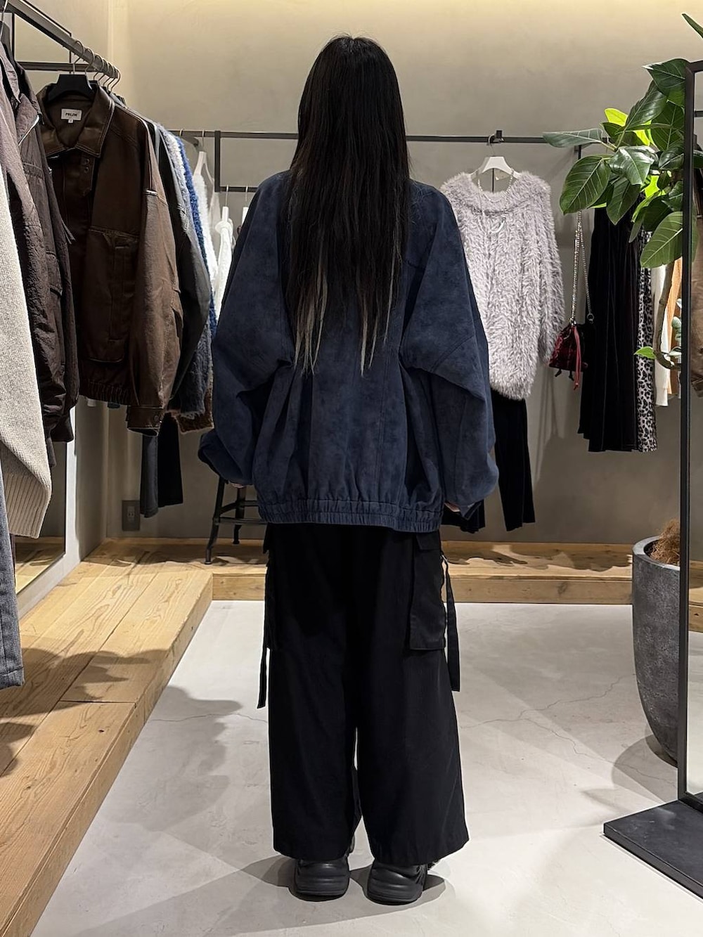 ブラック系のブーツ、ブラック系のスラックス、ブルー系のブルゾンを着用したレディースの冬コーディネートの3枚目の写真