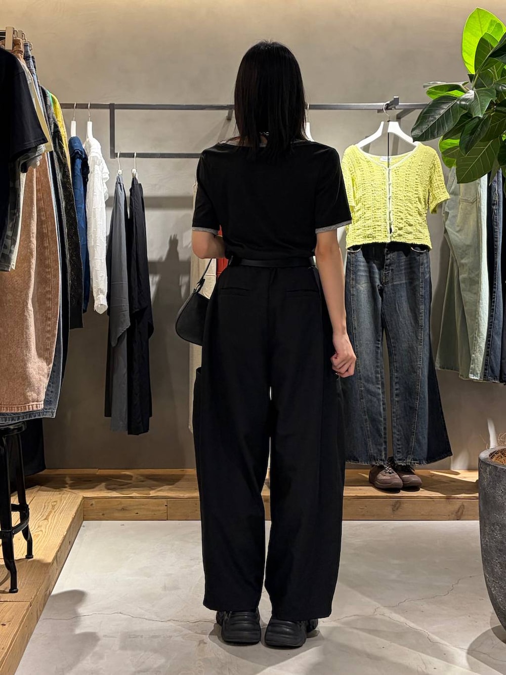 ブラック系のハンドバッグ、ブラック系のその他パンツ、ブラック系のTシャツ/カットソーを着用したレディースの春コーディネートの3枚目の写真