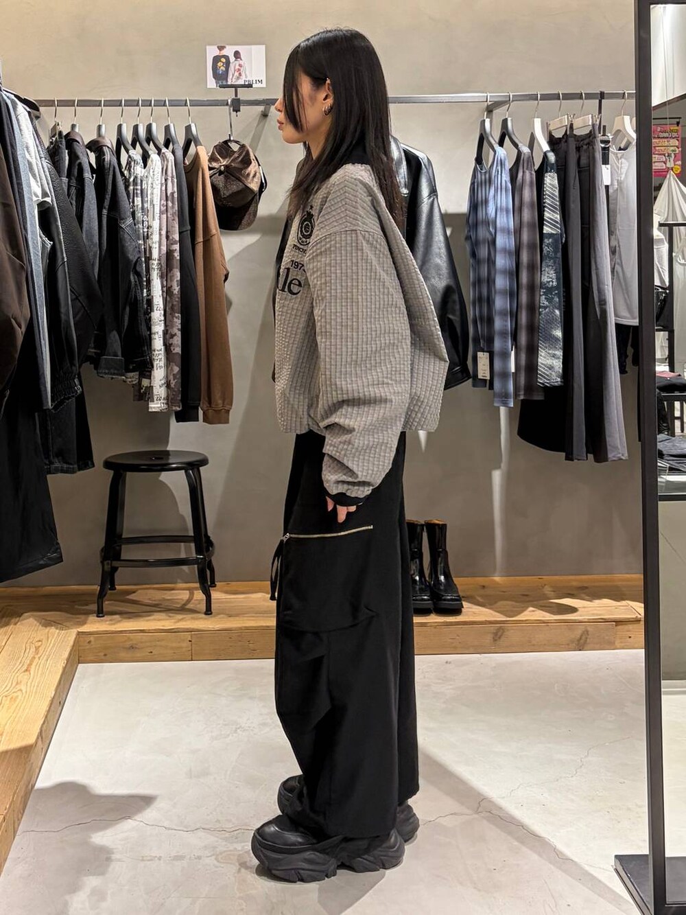 ブラック系のカーゴパンツ、グレー系のポロシャツ、ブラック系のブーツを着用したレディースの秋コーディネートの2枚目の写真