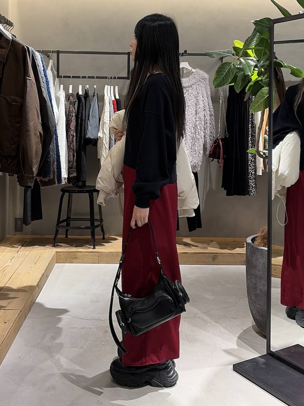 ブラック系のブーツ、ホワイト系のブルゾン、ブラック系のニット/セーターを着用したレディースの冬コーディネートの2枚目の写真