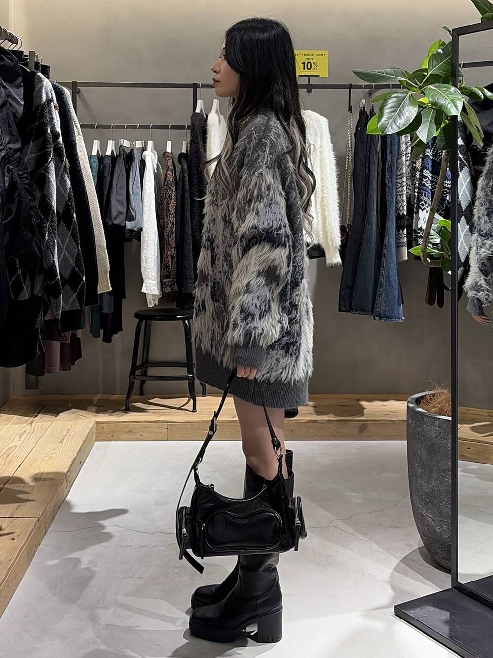 ブルー系のTシャツ/カットソー、グレー系のカーディガン/ボレロ、ブラック系のブーツを着用したレディースの秋コーディネートの2枚目の写真