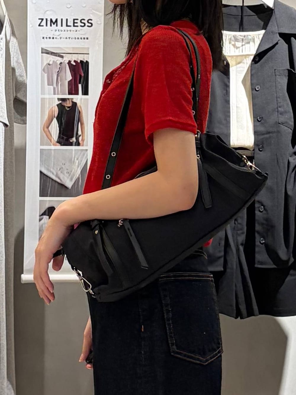 ブルー系のデニムパンツ、ブラック系のサンダル、ブラック系のトートバッグを着用したレディースの春コーディネートの6枚目の写真