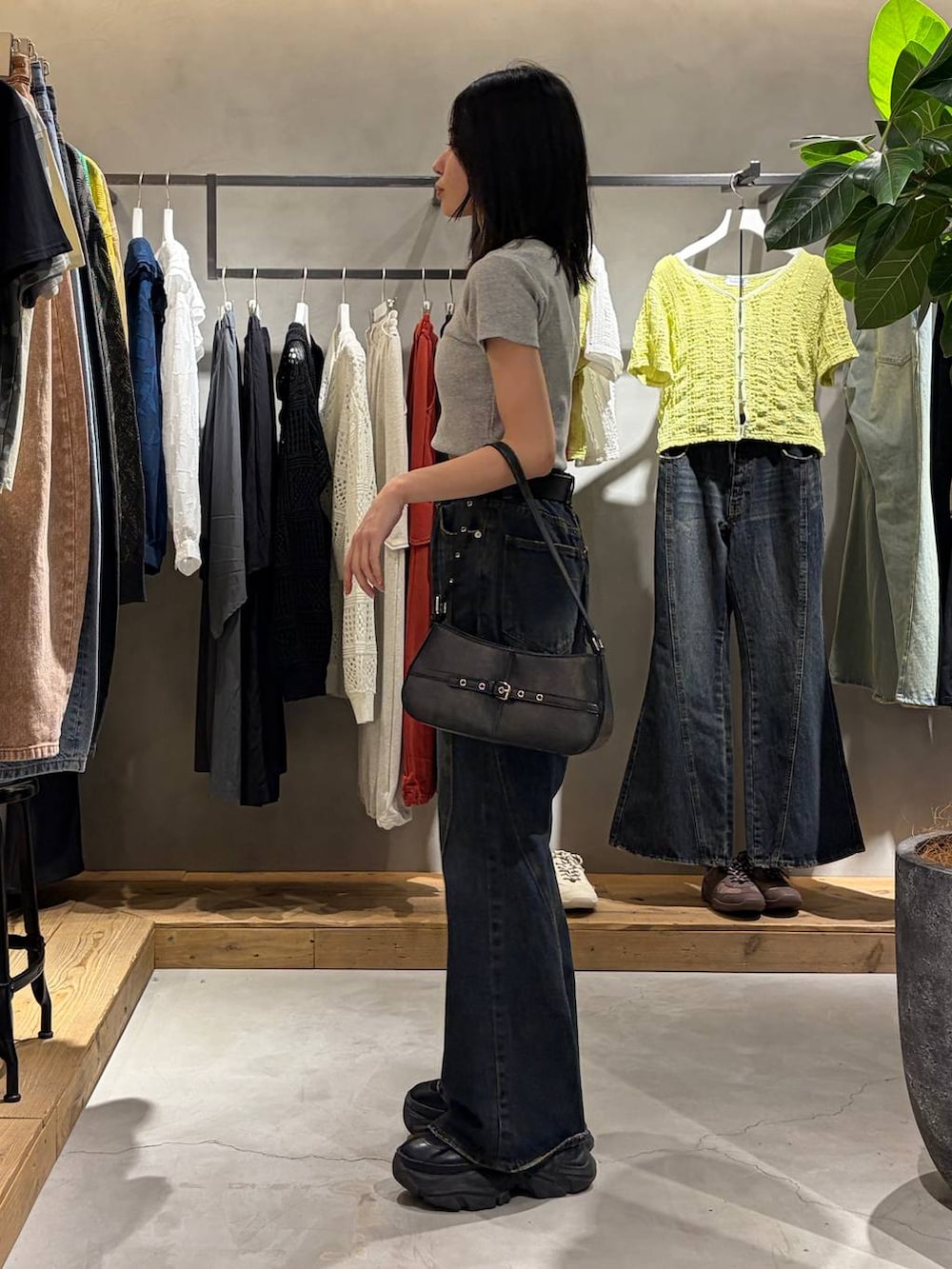 ブルー系のデニムパンツ、ブラック系のハンドバッグ、グレー系のTシャツ/カットソーを着用したレディースの春コーディネートの2枚目の写真