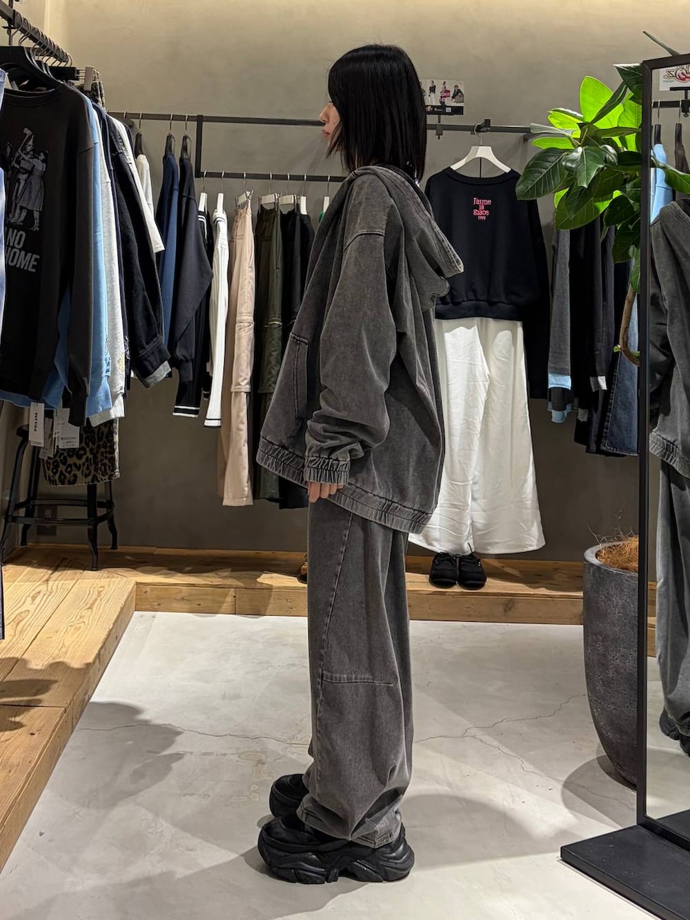 ブラック系のブーツ、ブラック系のデニムパンツ、ブラック系のパーカーを着用したレディースの春コーディネートの2枚目の写真