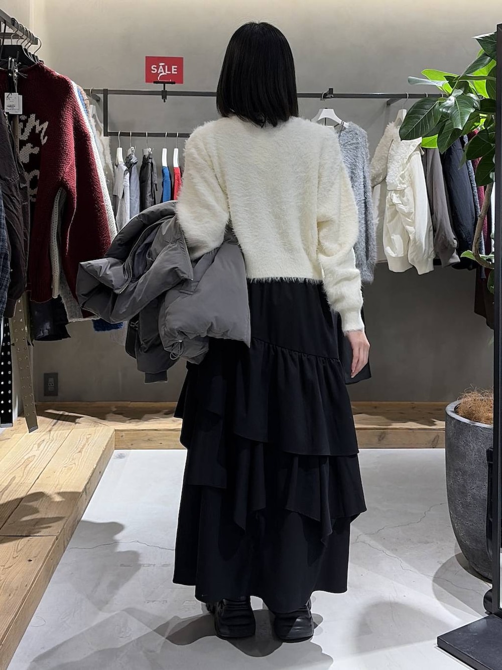 グレー系のブルゾン、ブラック系のスカート、ブラック系のボストンバッグを着用したレディースの冬コーディネートの3枚目の写真