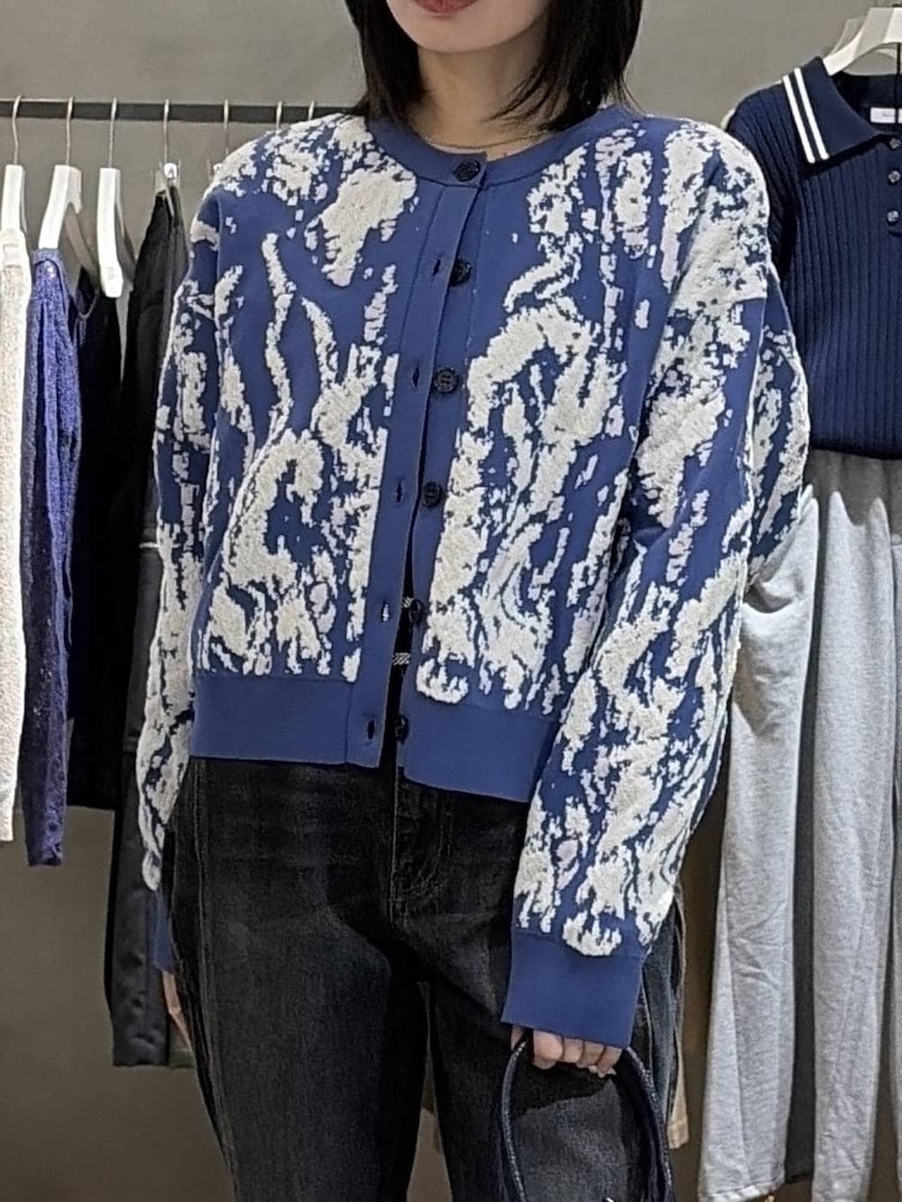 ブラック系のブーツ、ブルー系のデニムパンツ、ブルー系のハンドバッグを着用したレディースの冬コーディネートの4枚目の写真