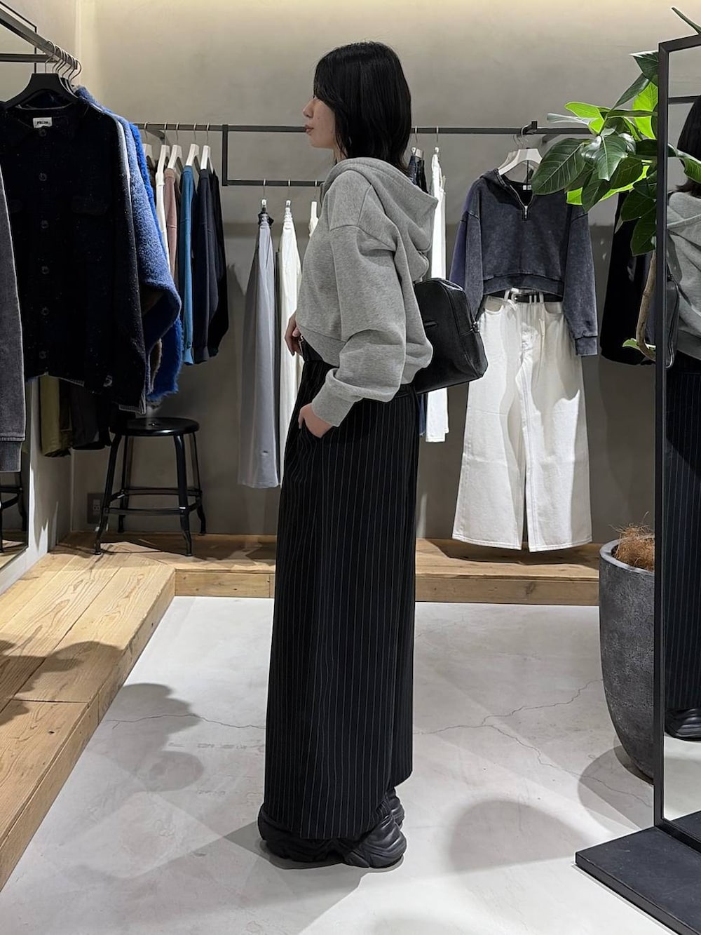 ブラック系のブーツ、ブラック系のボストンバッグ、グレー系のパーカーを着用したレディースの冬コーディネートの2枚目の写真