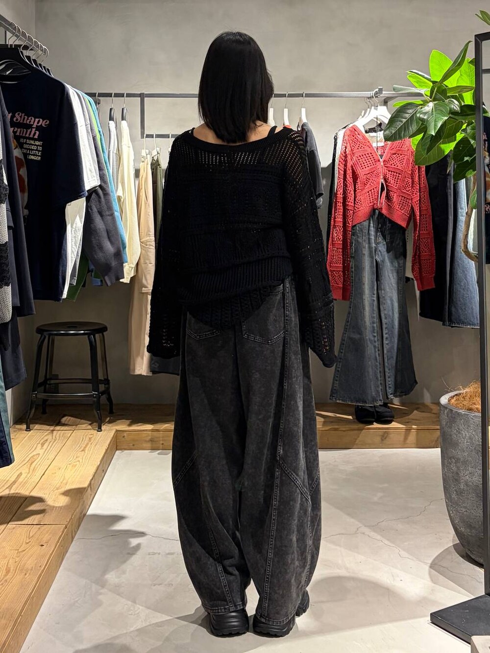 ブラック系のブーツ、ブラック系のデニムパンツ、ブラック系のニット/セーターを着用したレディースの春コーディネートの3枚目の写真