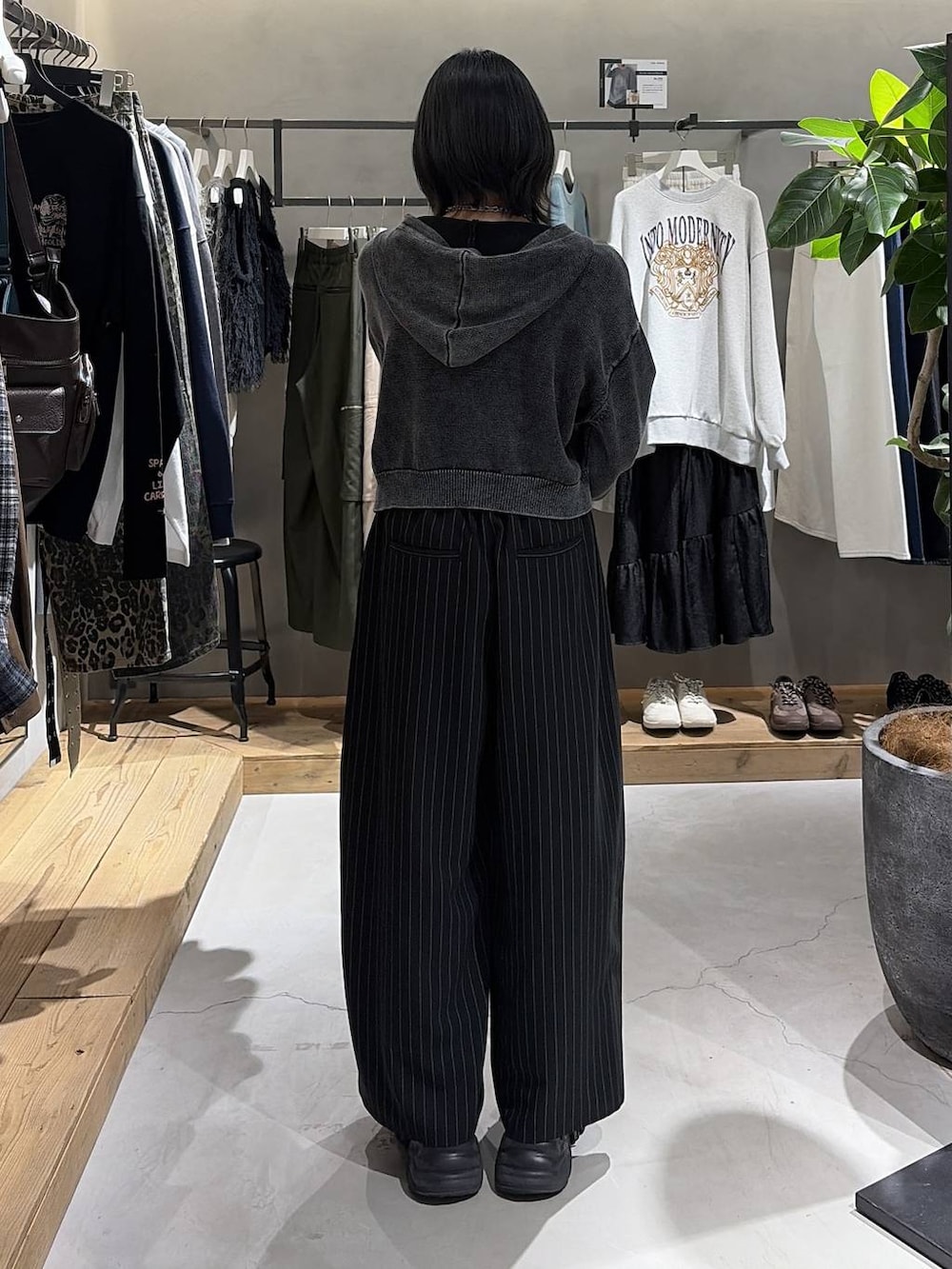 ブラック系のボストンバッグ、ブラック系のスラックス、グレー系のパーカーを着用したレディースの冬コーディネートの3枚目の写真