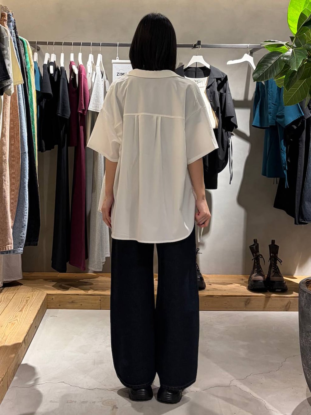 ブルー系のデニムパンツ、ブラック系のサンダル、ホワイト系のシャツ/ブラウスを着用したレディースの春コーディネートの3枚目の写真