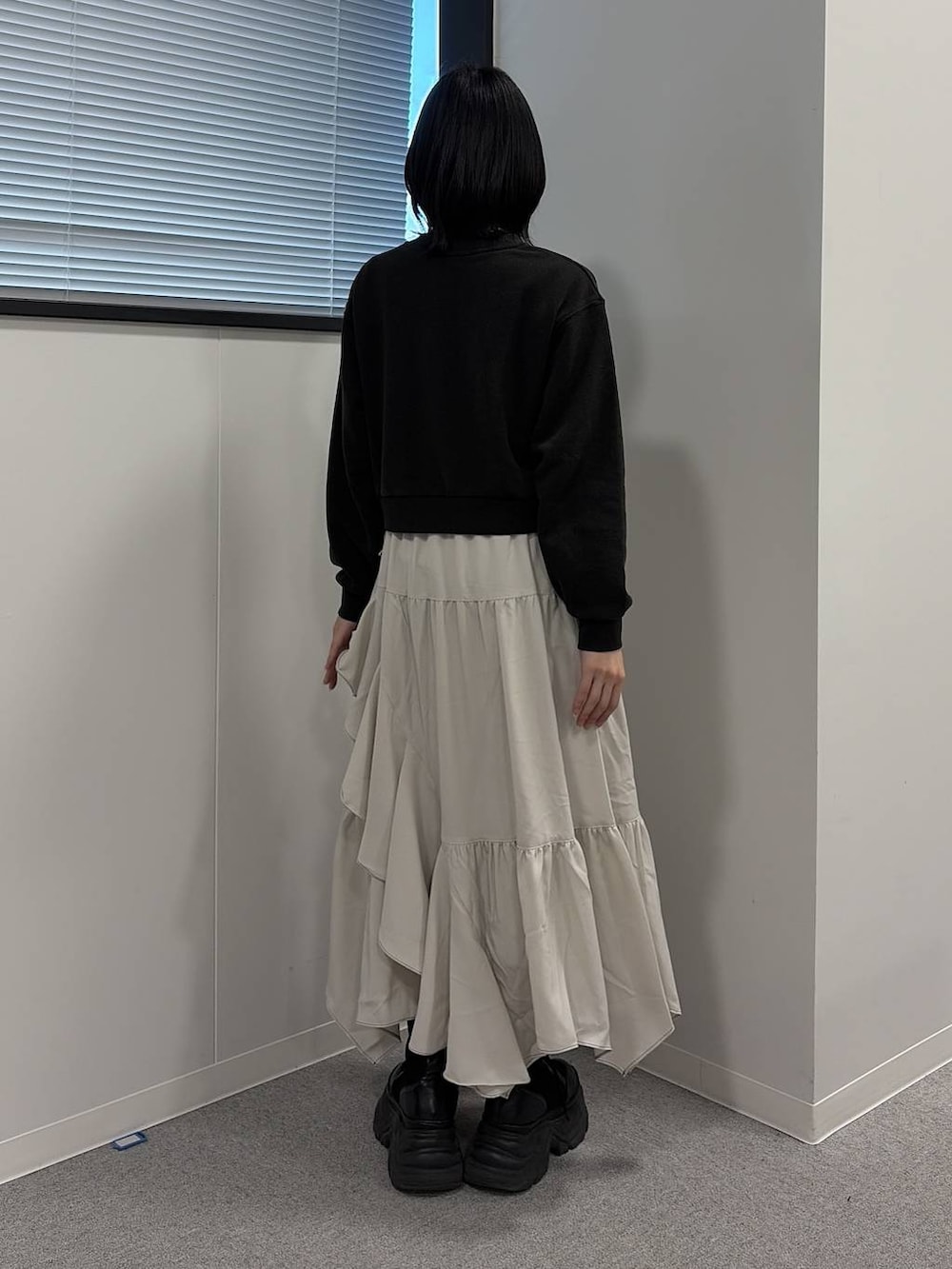 ブラック系のブーツ、ベージュ系のスカート、グレー系のスウェットを着用したレディースの冬コーディネートの3枚目の写真